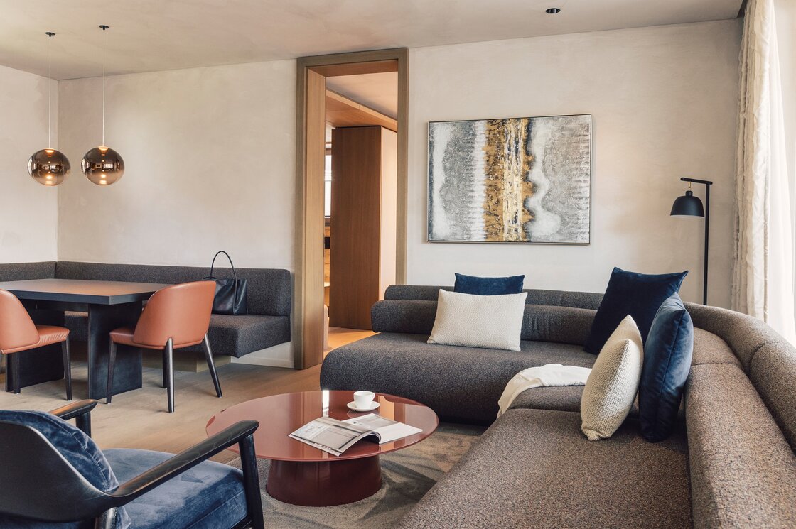 Gemütlicher Wohnbereich mit Sofa, Esstisch und Designlampen in einem Apartment.