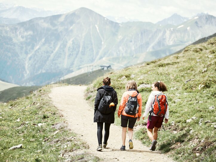Wandergruppe auf Bergweg in Fiss Drei Wanderinnen gehen auf einem Bergweg durch die Alpen.