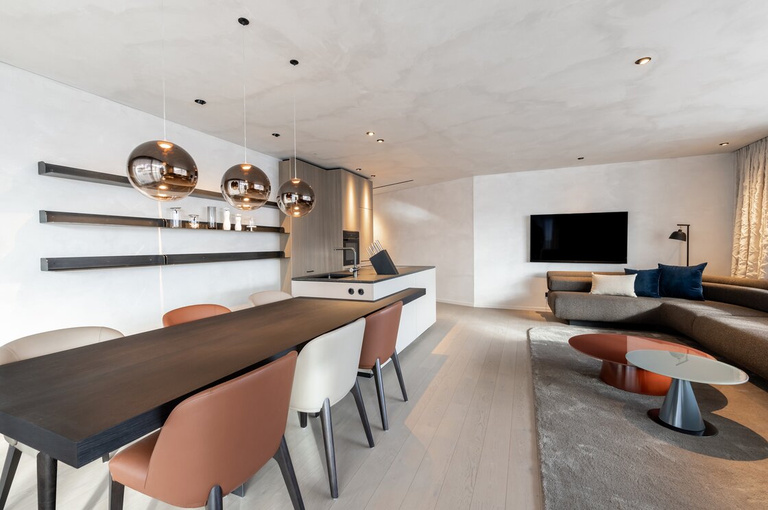 Offener Wohn- und Essbereich eines Luxury Apartment mit moderner Küche, Sofa und Esstisch.