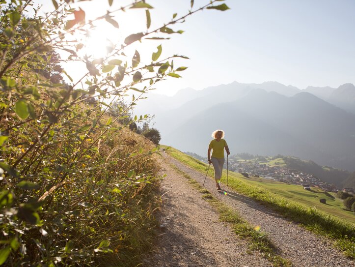 Wandern in Fiss mit Bergblick Eine Frau wandert mit Stöcken auf einem Bergweg oberhalb von Fiss.