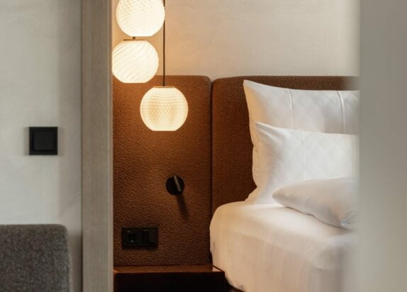 Fiss Apartment 3, Schlafzimmer mit Ausschnitt vom Bett und Lampe