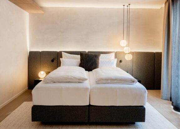 Appartement Fiss 4, Schlafzimmer Doppelbett mit weißem Bettbezug und einem braunen Kissen