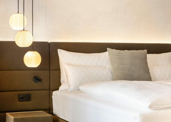 Ferienwohnung Fiss 4 - Schlafzimmer mit Bett, Kissen und Design Lampen