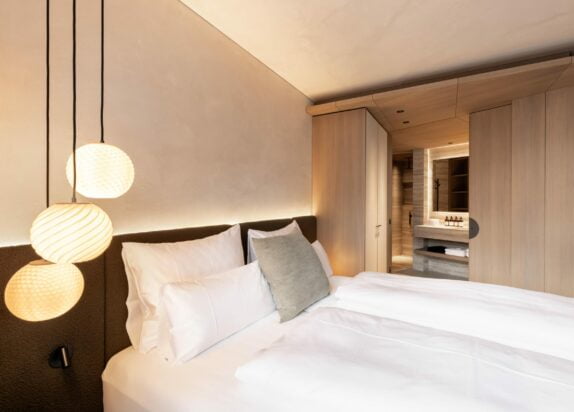 Ferienwohnung Fiss 5 - Schlafzimmer mit Bett, Bad und Design Lampen