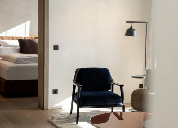 Ferienwohnung Fiss 6  - Wohnzimmer mit Design Stuhl und Lampe