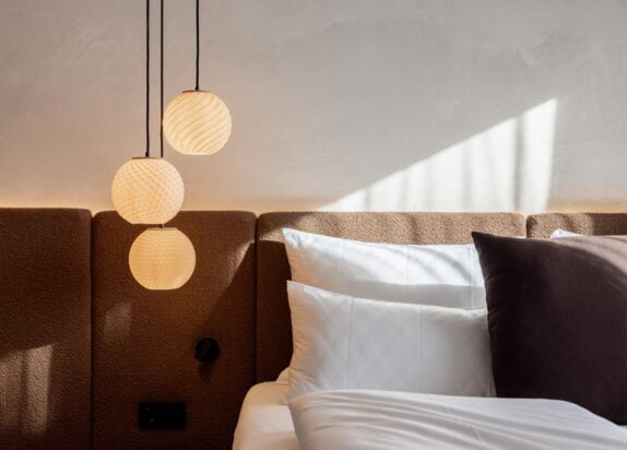 Fiss Ferienwohnung Penthouse 2, Schlafzimmer mit weißem Bettbezug und Designlampe