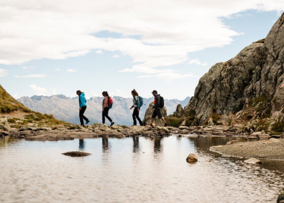 Wandern in Serfaus Fiss Ladis, Gruppe läuft neben einem kleinen Bergsee