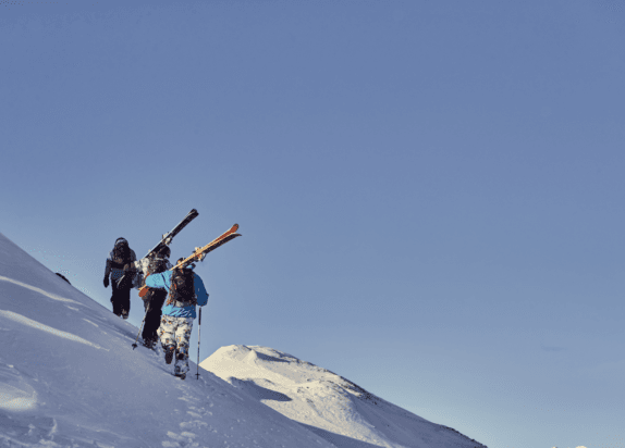 Fiss ski resort, skiers run up a mountain to freeride