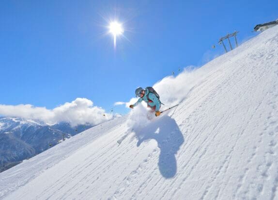 Fiss ski resort, skiers in fresh snow, sun shining