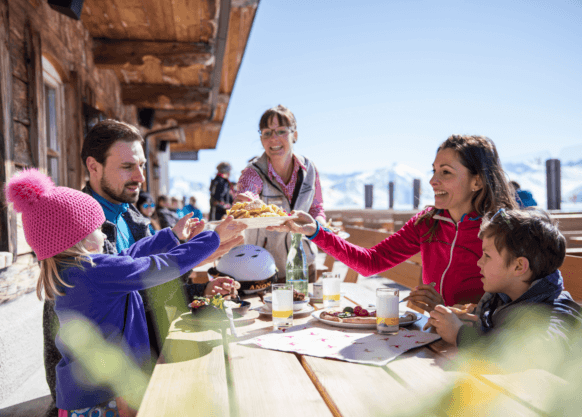 Serfaus-Fiss-Ladis Winter - Restaurant Lassida, Familie stößt mit Getränken an