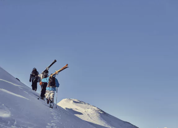 Fiss ski resort, skiers run up a mountain to freeride