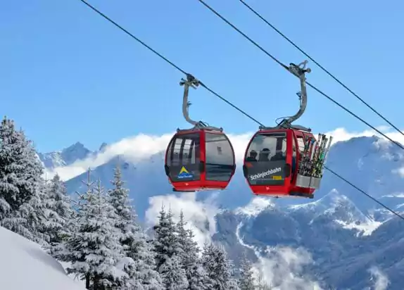 Schönjochbahn im Fiss Skigebiet, Gondel mit Urlaubern und Skiern bei Neuschnee und Sonnenschein