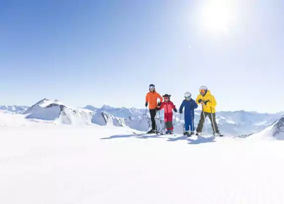 Familienurlaub in den Bergen - Familie Skifahren, blauer Himmel