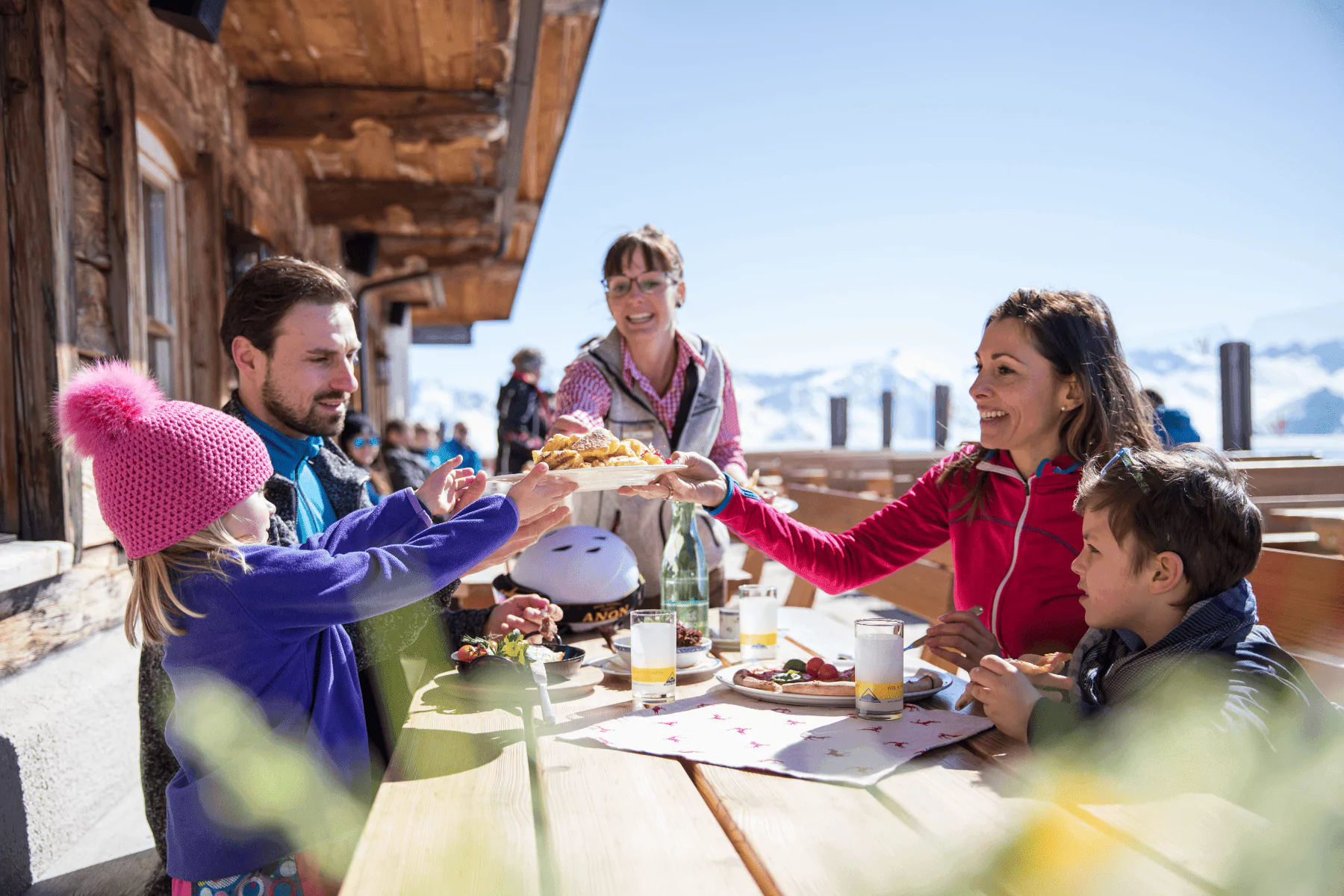 Serfaus-Fiss-Ladis Winter - Restaurant Lassida, Familie stößt mit Getränken an