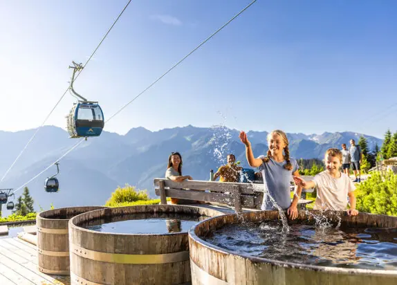 Wasserspielplatz Serfaus Fiss Ladis, Kinder spielen an Wasserfässern